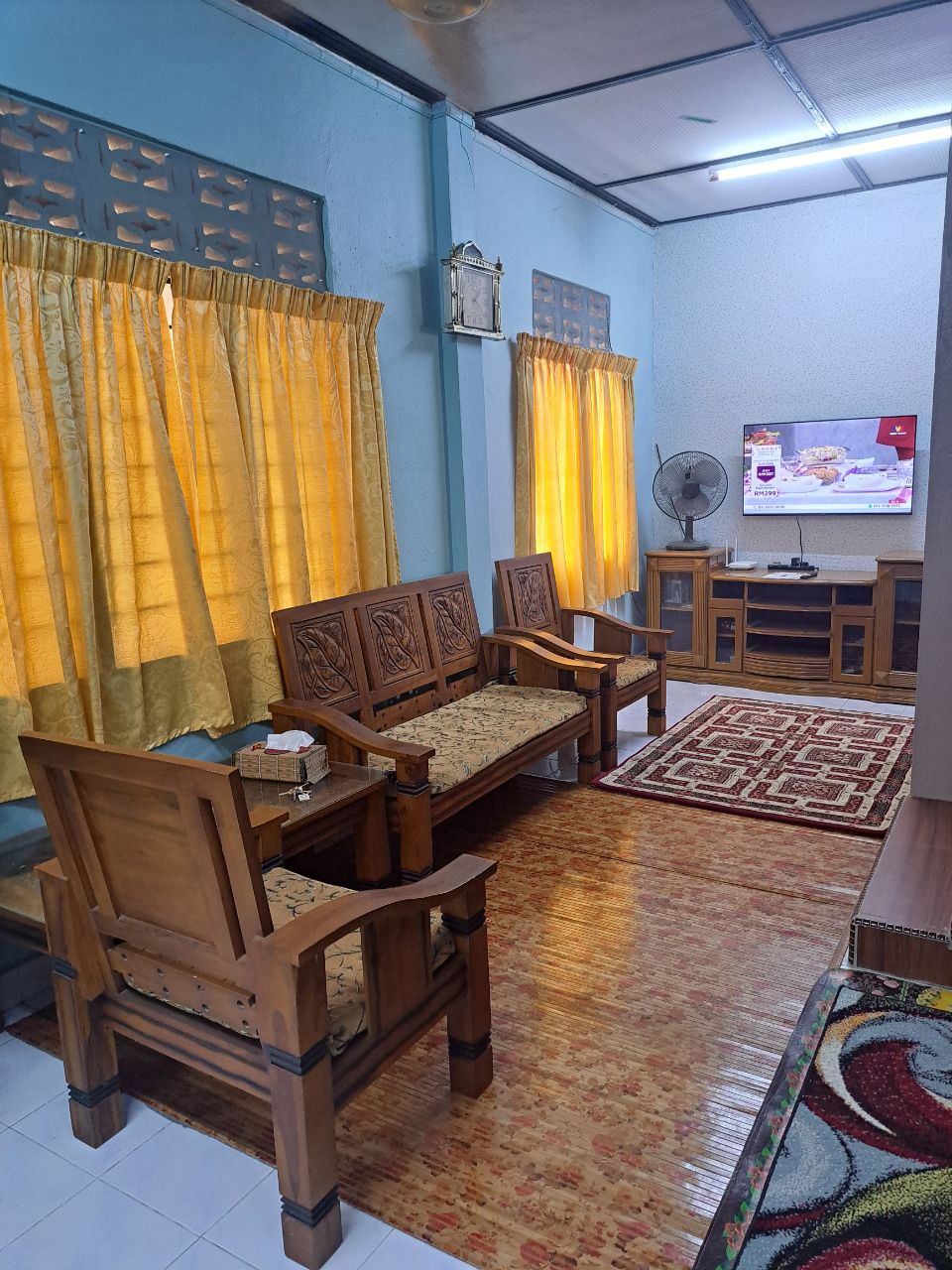 Ground-floor living room with wooden sofa set and TV