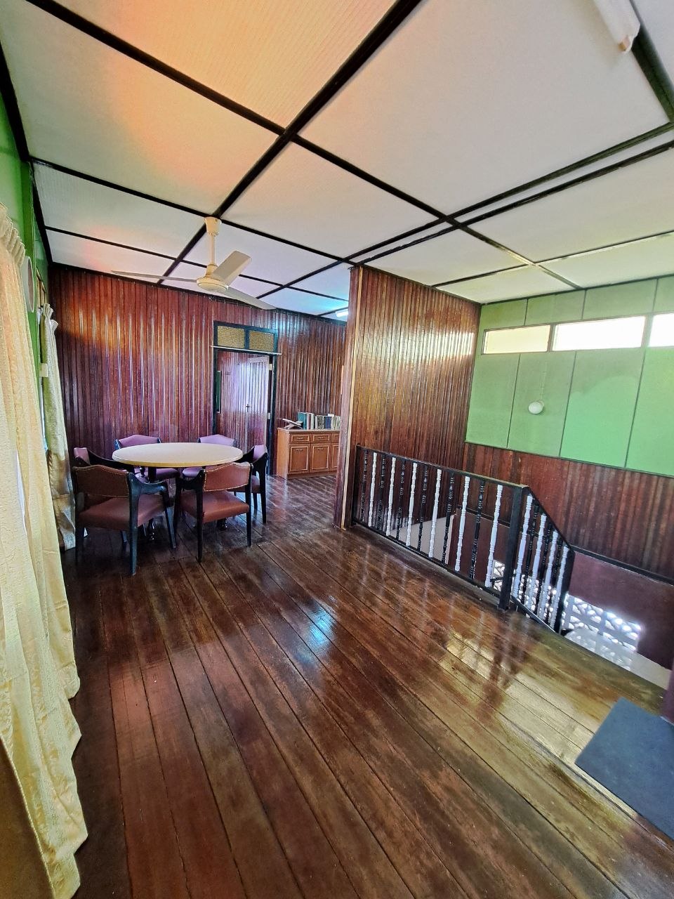 Ground-floor living room with wooden sofa set and TV